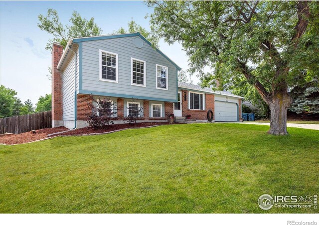 tri-level home featuring a front lawn and a garage