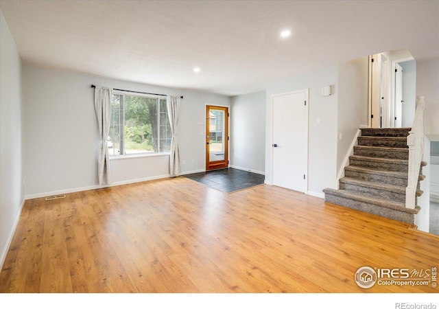 interior space featuring recessed lighting, wood finished floors, visible vents, baseboards, and stairs