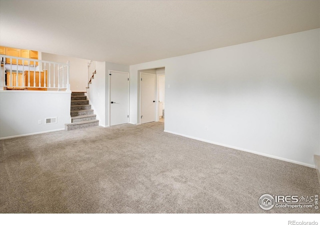 unfurnished living room with stairway, carpet, visible vents, and baseboards