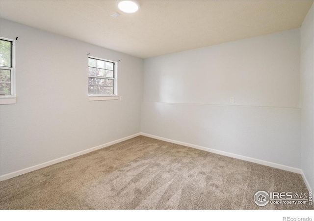 carpeted empty room with baseboards