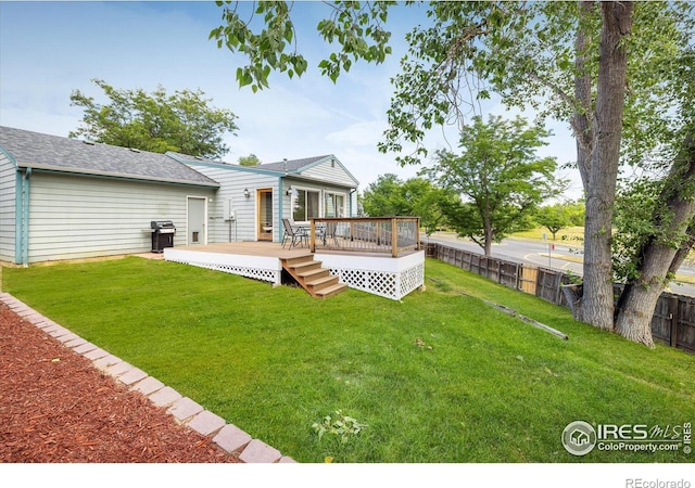 rear view of property featuring a deck, a lawn, and fence private yard