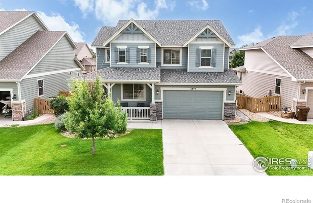 craftsman inspired home featuring a garage and a front lawn