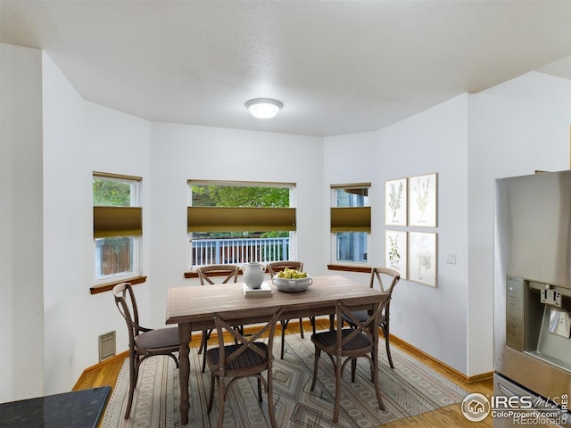 dining space with wood-type flooring