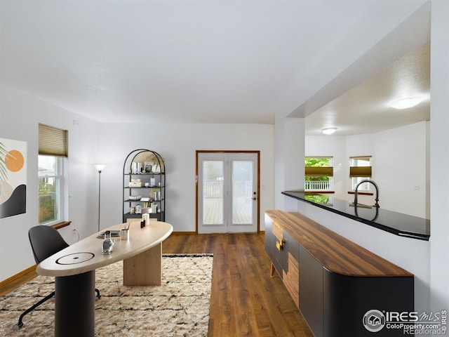 home office with plenty of natural light and dark wood-type flooring