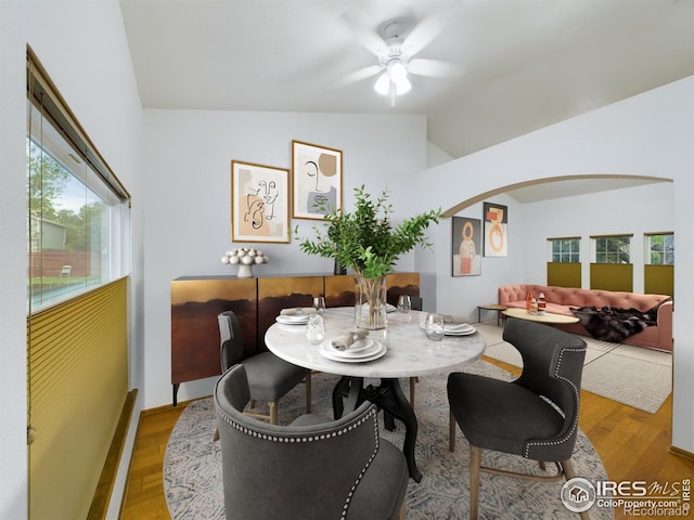 dining room with ceiling fan, wood-type flooring, and lofted ceiling