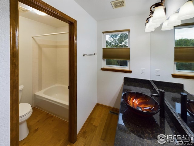 full bathroom featuring shower / bath combination, wood-type flooring, a notable chandelier, and toilet