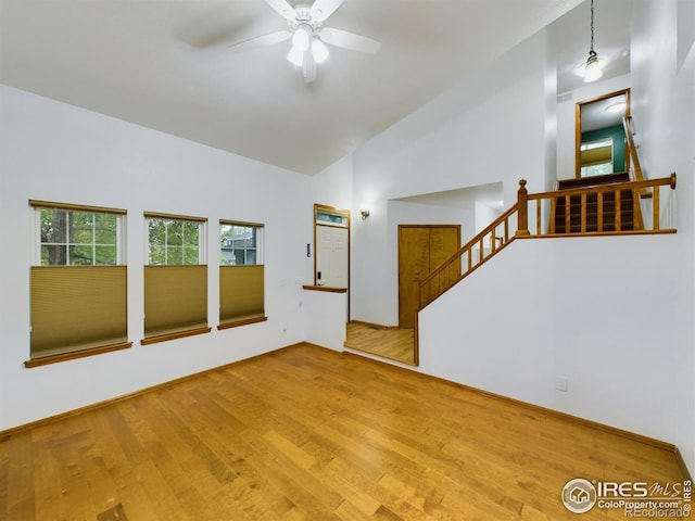 2720 E 121st Pl, Thornton, CO 80241 - unfurnished living room featuring wood finished floors, high vaulted ceiling, stairs, and ceiling fan