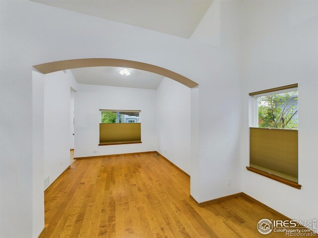 2720 E 121st Pl, Thornton, CO 80241 - corridor with arched walkways, light wood finished floors, and baseboards