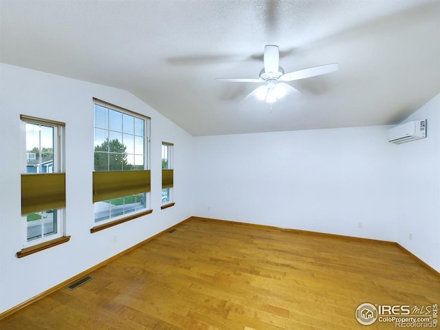 2720 E 121st Pl, Thornton, CO 80241 - spare room featuring vaulted ceiling, visible vents, a wall mounted air conditioner, a ceiling fan, and wood finished floors