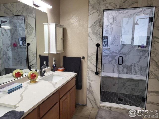 bathroom featuring a marble finish shower and vanity