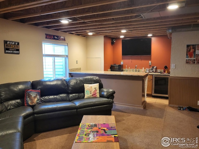 living area with a wainscoted wall, wine cooler, indoor wet bar, and wood walls