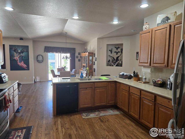 kitchen with dark wood-style floors, a peninsula, stainless steel appliances, light countertops, and a sink