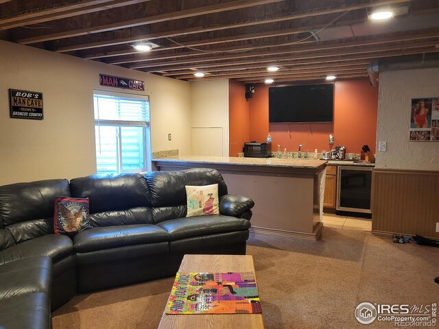 living room with wet bar, beverage cooler, wainscoting, and wooden walls