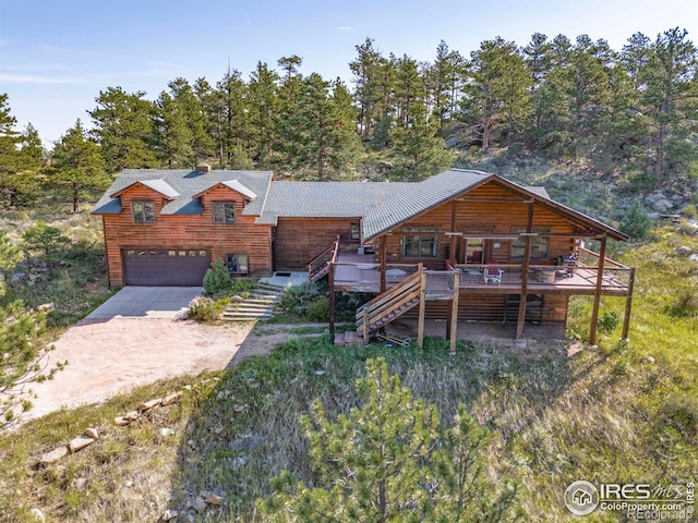 log cabin featuring a wooden deck and a garage