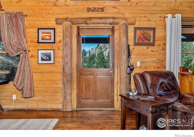 entrance foyer with log walls and wood-type flooring