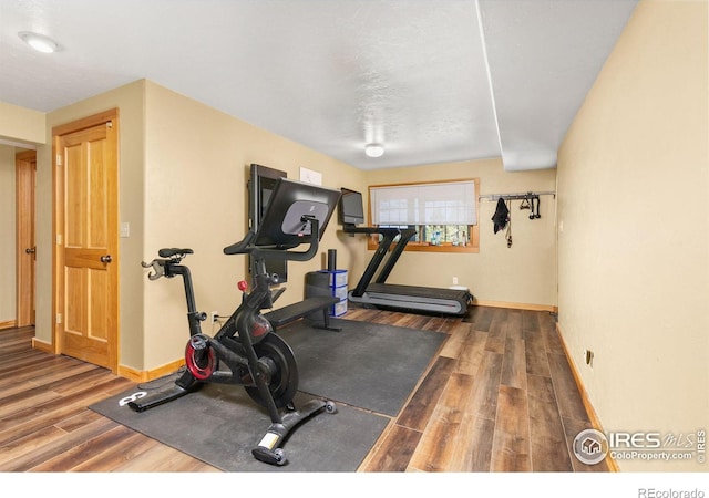 workout room featuring a textured ceiling and dark hardwood / wood-style floors