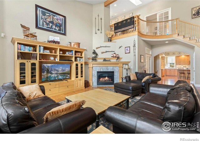 living room featuring a fireplace, a high ceiling, and wood-type flooring