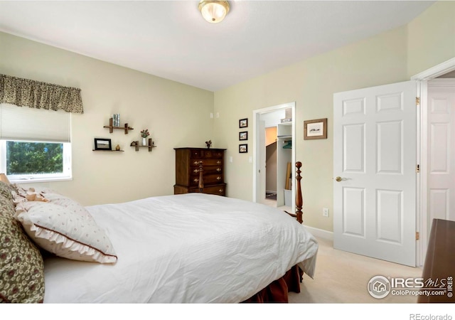 bedroom featuring a walk in closet, a closet, and light colored carpet