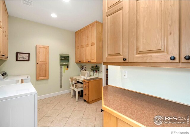 laundry area featuring light tile patterned floors, cabinets, and washer and dryer