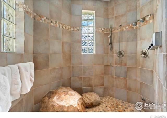 bathroom with tile walls and tiled shower