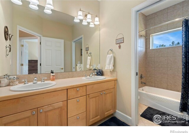 bathroom featuring tiled shower / bath combo, dual vanity, and tile patterned floors