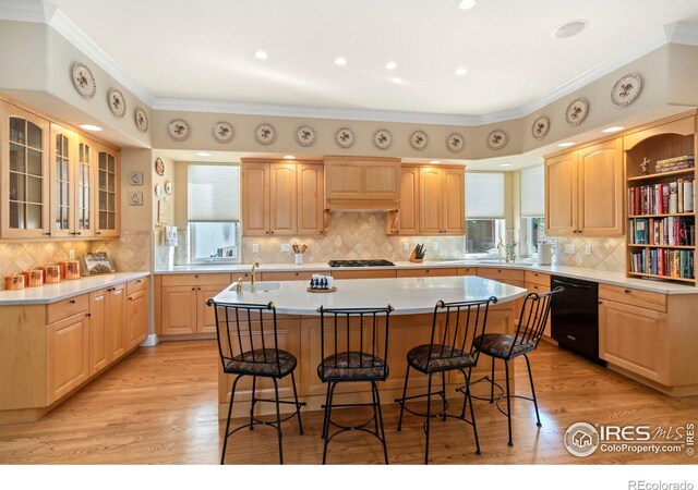 kitchen featuring black dishwasher, a center island, premium range hood, and light hardwood / wood-style flooring