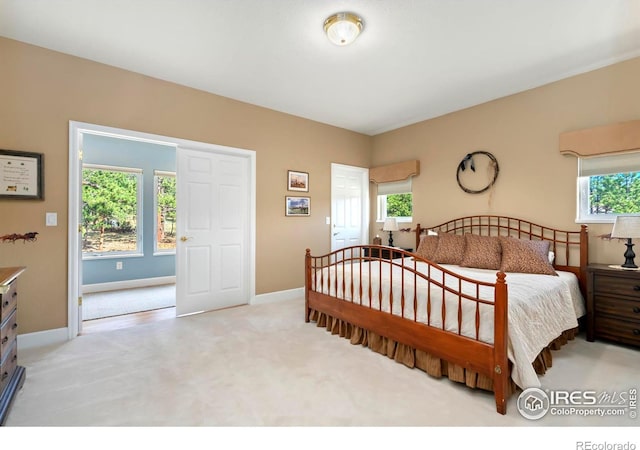 bedroom with multiple windows and light carpet