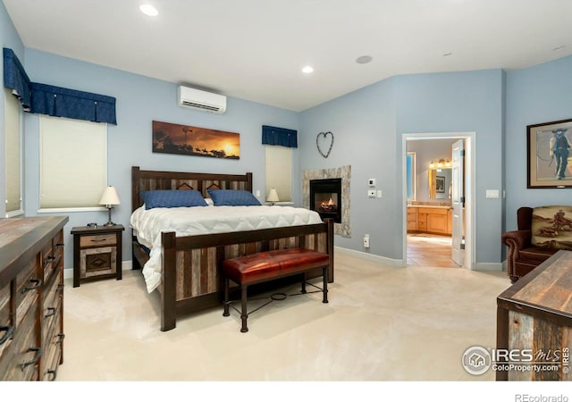 carpeted bedroom featuring an AC wall unit and ensuite bathroom