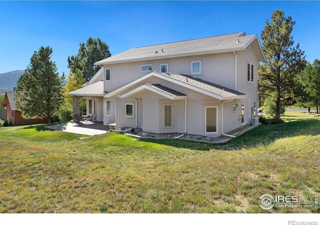 rear view of house featuring a lawn, central AC, and a patio area