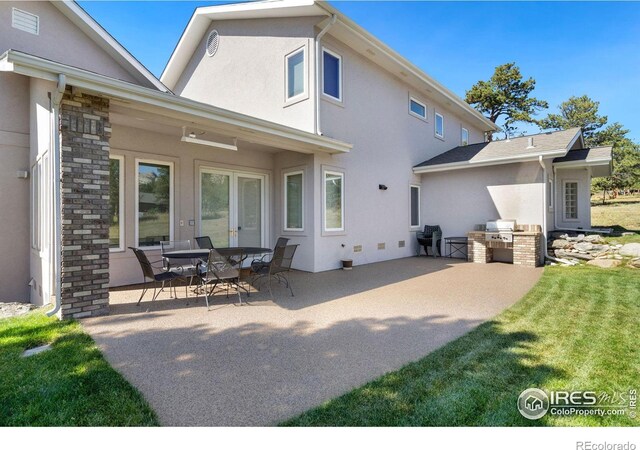 rear view of house with a lawn and a patio