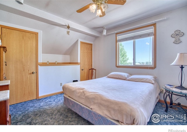 bedroom with vaulted ceiling, dark colored carpet, and ceiling fan