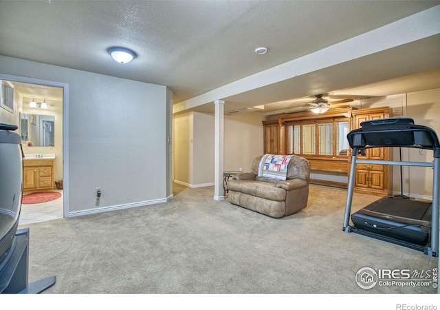 exercise area featuring carpet, a textured ceiling, and ceiling fan