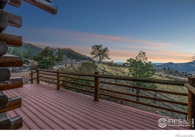 deck at dusk featuring a mountain view