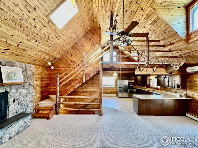 interior space featuring wooden ceiling, wooden walls, a wall unit AC, light carpet, and appliances with stainless steel finishes