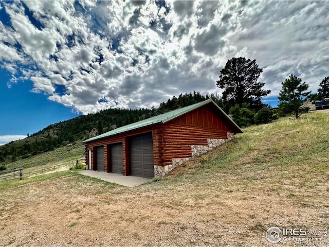 detached garage with a mountain view and fence