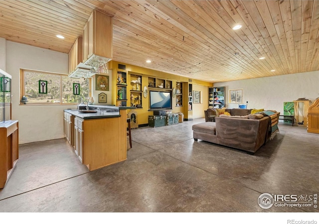 kitchen featuring concrete floors, a breakfast bar area, wood ceiling, and kitchen peninsula