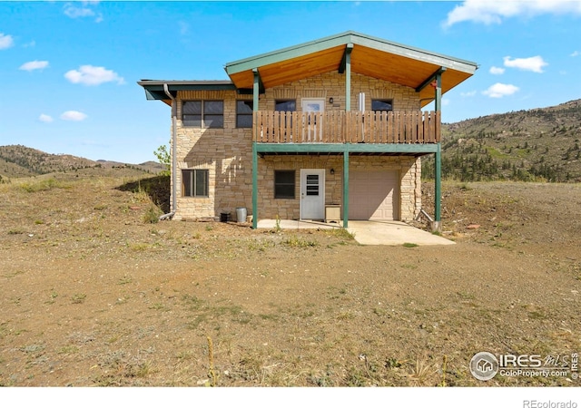 rear view of house featuring a mountain view and a garage