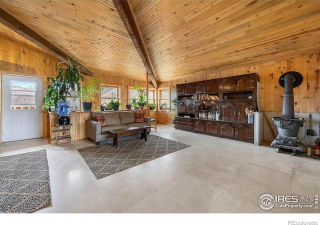 tiled living room featuring lofted ceiling with beams, a wealth of natural light, wooden ceiling, and a wood stove