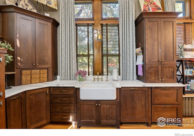 kitchen featuring light stone counters and sink