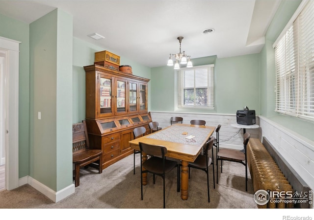 carpeted dining area featuring a chandelier