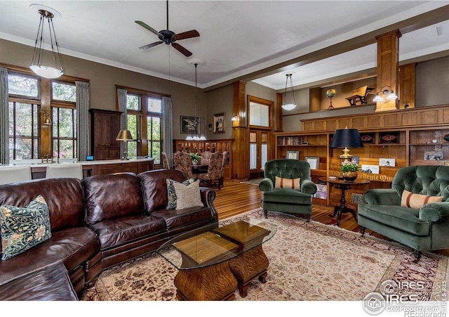 living room featuring crown molding, wood-type flooring, and ceiling fan