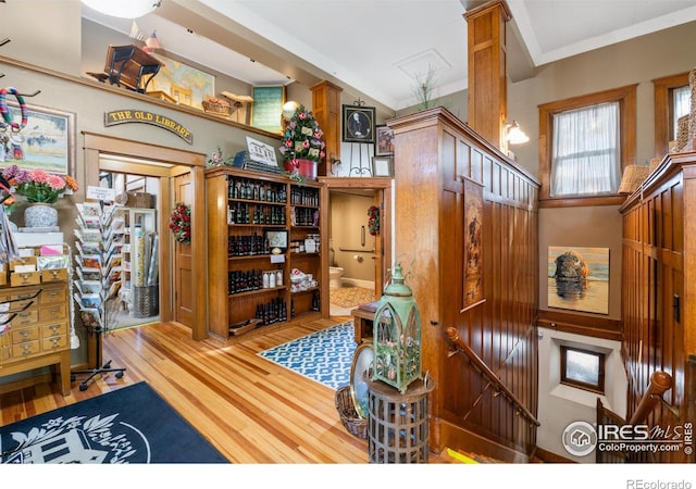 interior space featuring hardwood / wood-style flooring, ornamental molding, and decorative columns