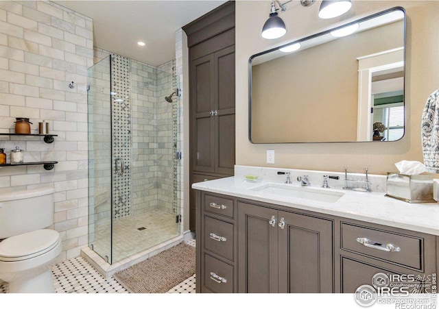 bathroom featuring tile patterned floors, toilet, a shower with shower door, and vanity