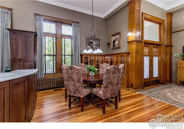 dining area featuring radiator heating unit, light hardwood / wood-style floors, and french doors