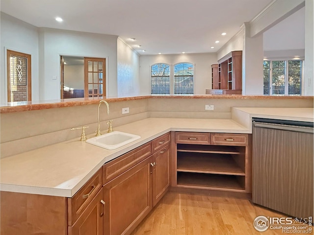 kitchen featuring ornamental molding, light hardwood / wood-style floors, sink, and kitchen peninsula