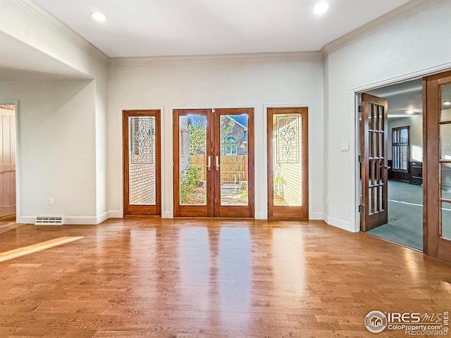 doorway featuring hardwood / wood-style flooring, ornamental molding, and french doors