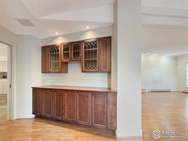 bar with light hardwood / wood-style floors and a baseboard heating unit