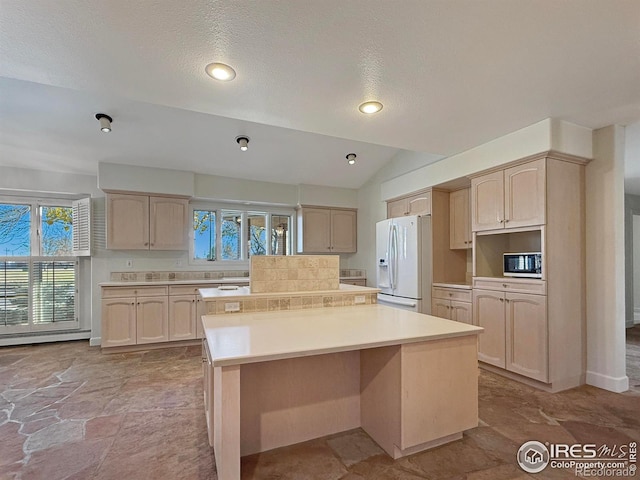 kitchen featuring white appliances, light brown cabinets, and a kitchen island