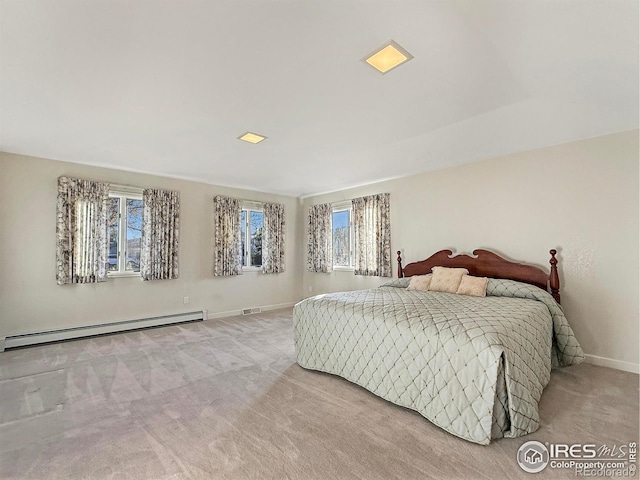 carpeted bedroom featuring baseboard heating and multiple windows