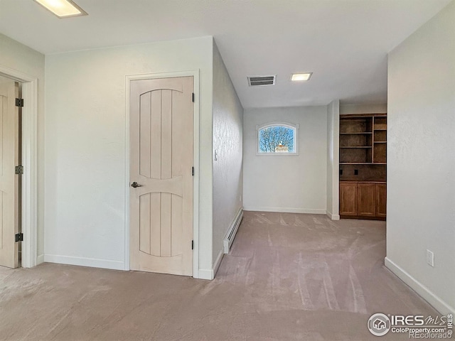 hall with baseboard heating and light colored carpet